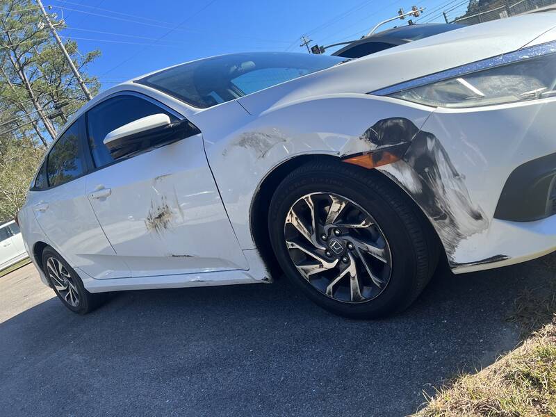 White Honda Civic with scrapes and black paint transfer along the front bumper, fender and door